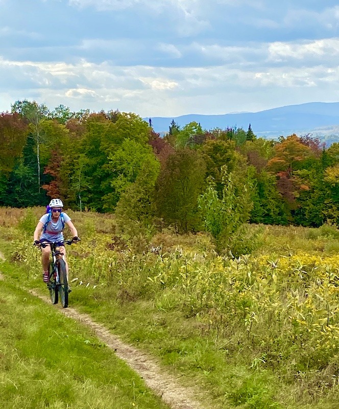 Woman Mountain biking on trail in Northeast Kingdom Outdoor Adventures