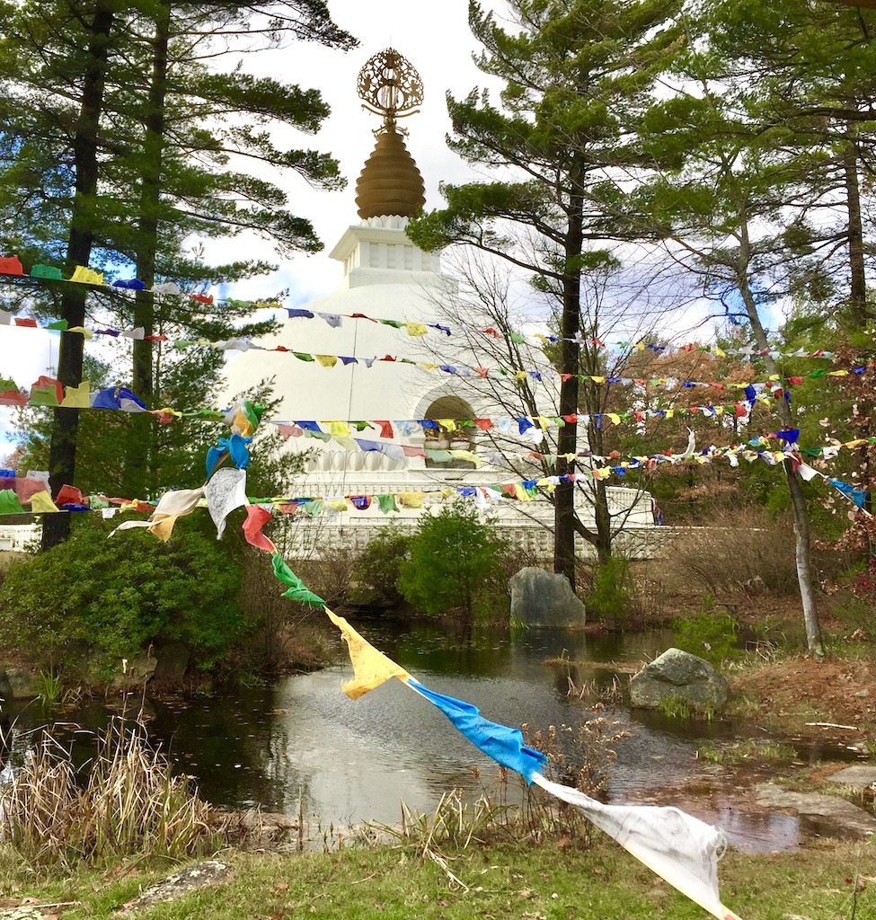 Peace Pagoda with prayer flags on an outdoor spiritual retreat