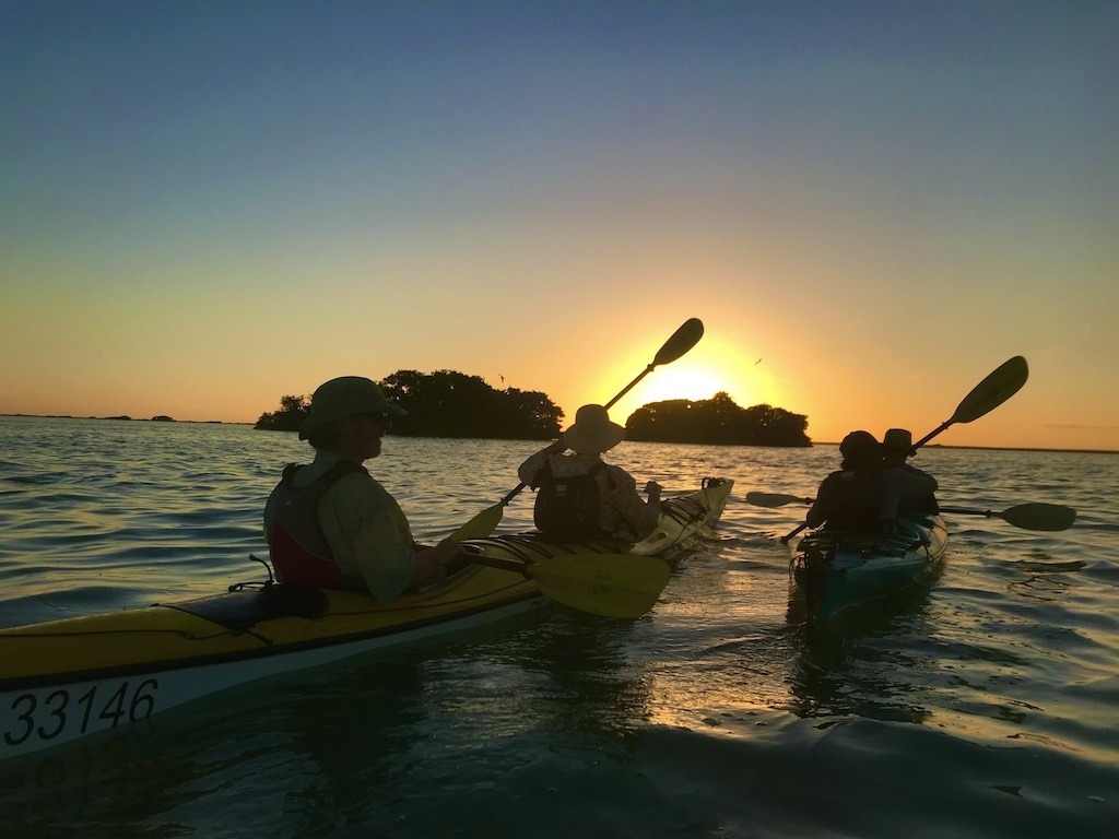 Paddlers at sunset while sea kayaking Sian Ka'an