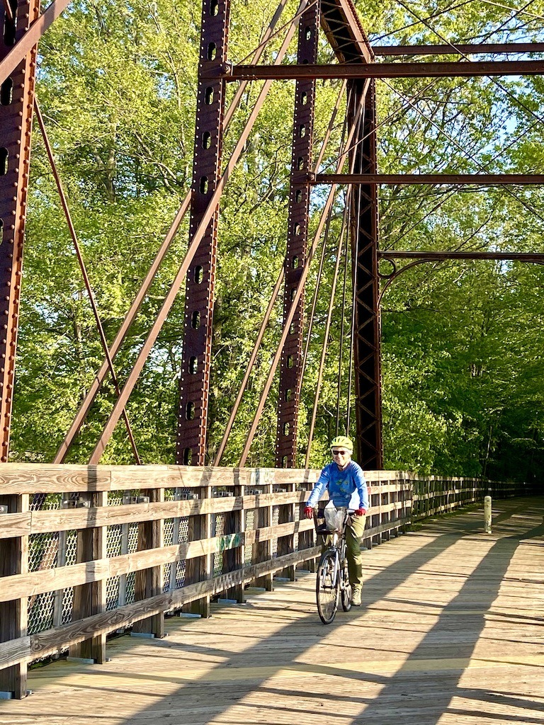 biker crossing bridge on one of the best bike trails in Western Massachusetts