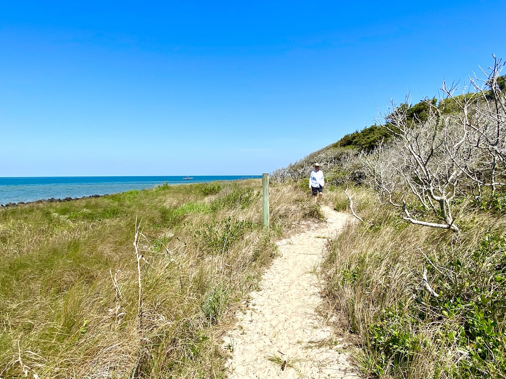 hiker on sand trail near ocean=one of the outdoor adventures on Ocracoke Island
