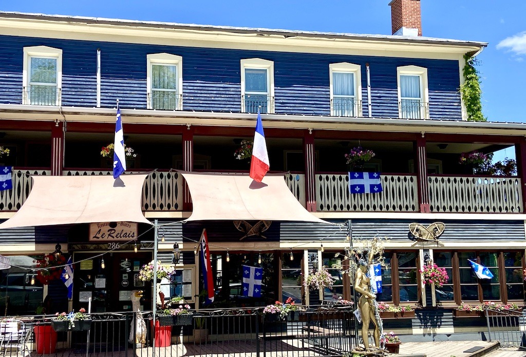 blue building with flags-Three Pines Tour in Search of Louise Penny's Inspirations 