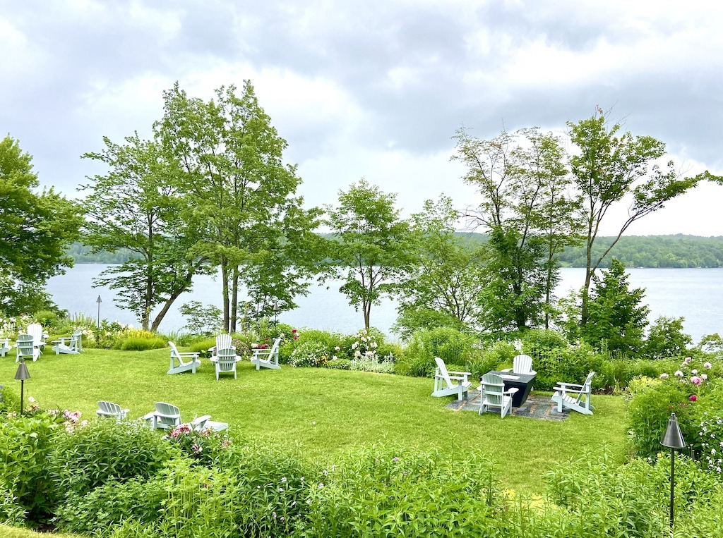 Garden with white chairs on lake- Three Pines Tour in Search of Louise Penny's Inspirations 