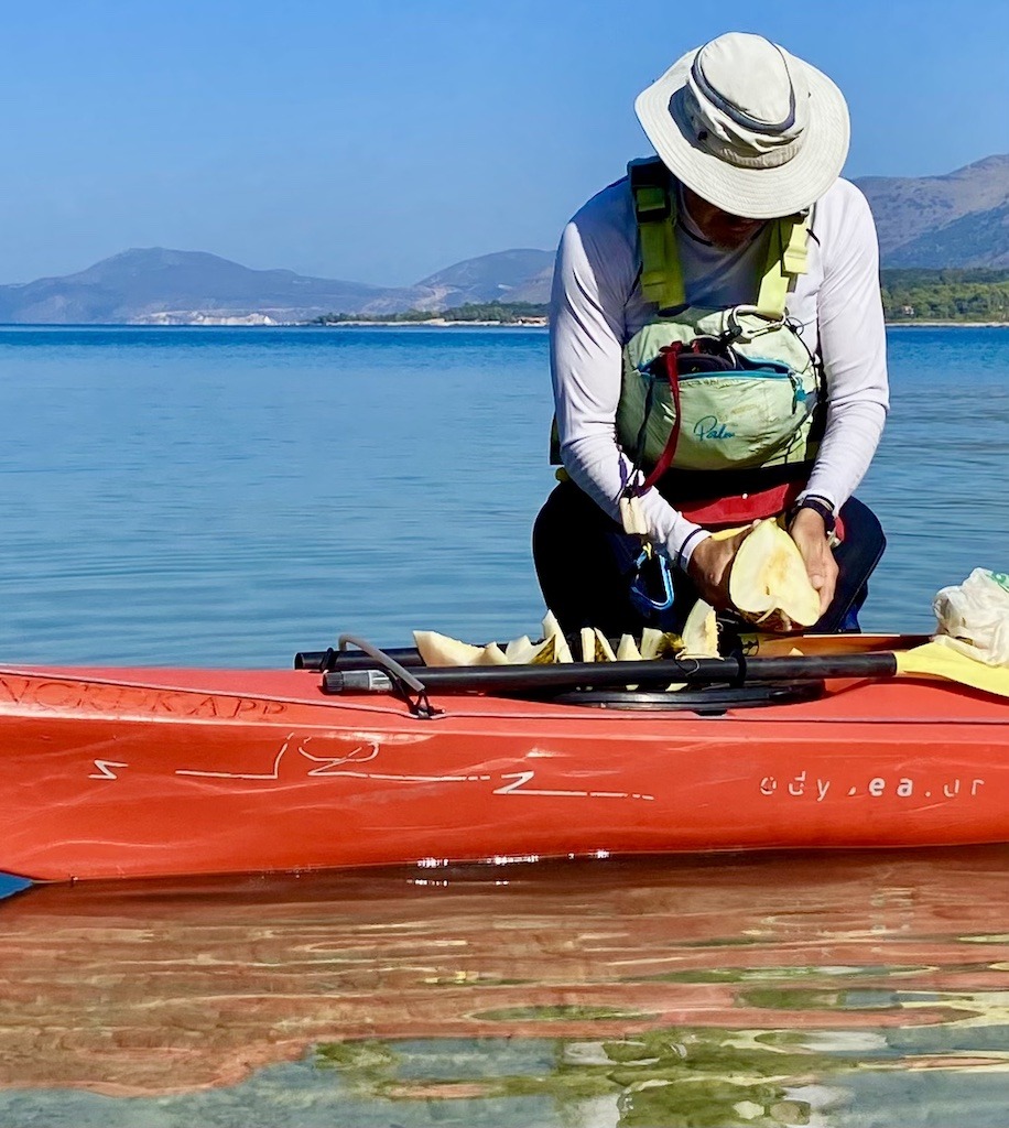 cutting melon on red boat-sea kayak on Kefalonia