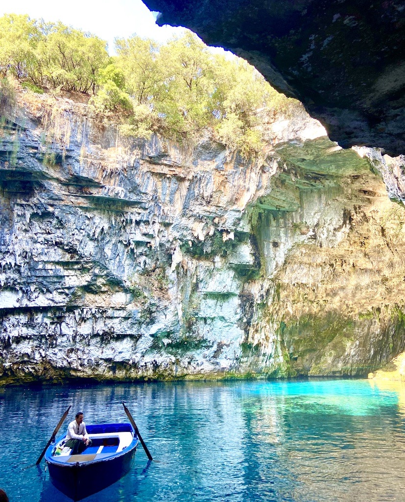 man and boat on blue waters in cave-Outdoor Adventures of Kefalonia