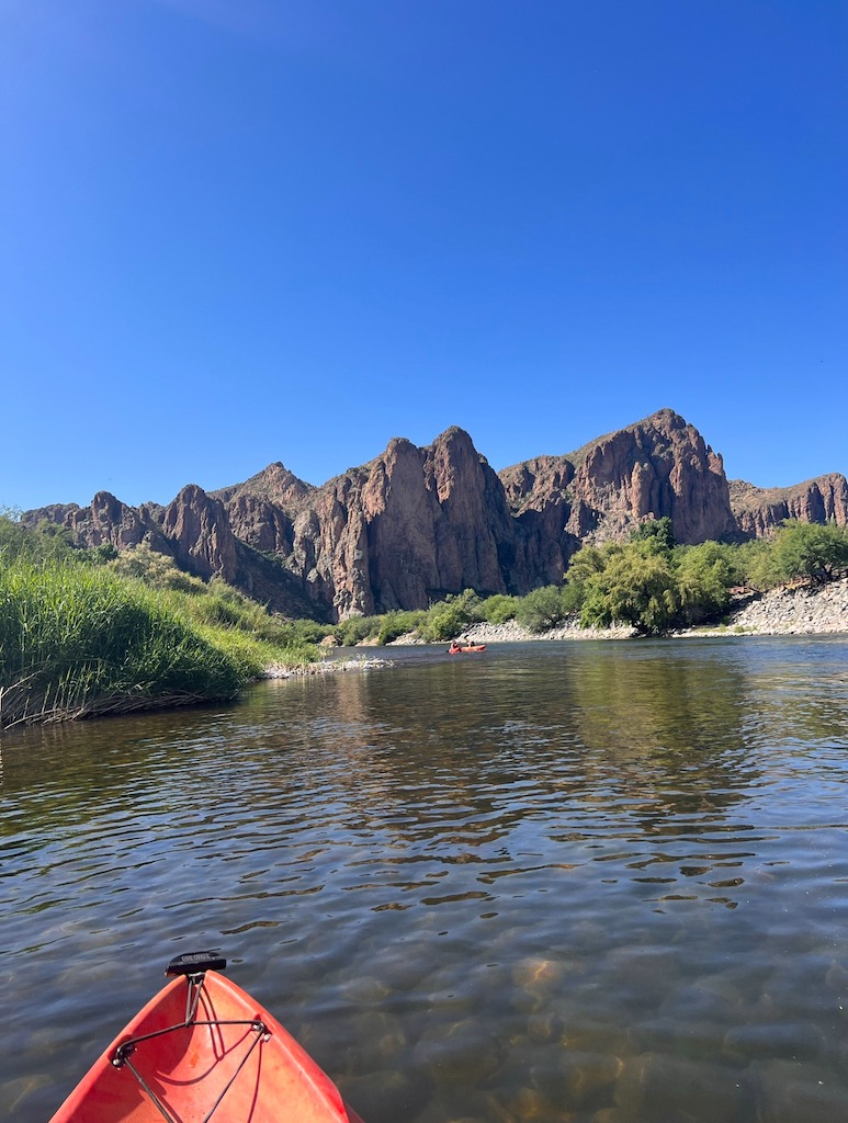 orange kayak with river and cliffs-best kayaking day trips in the US