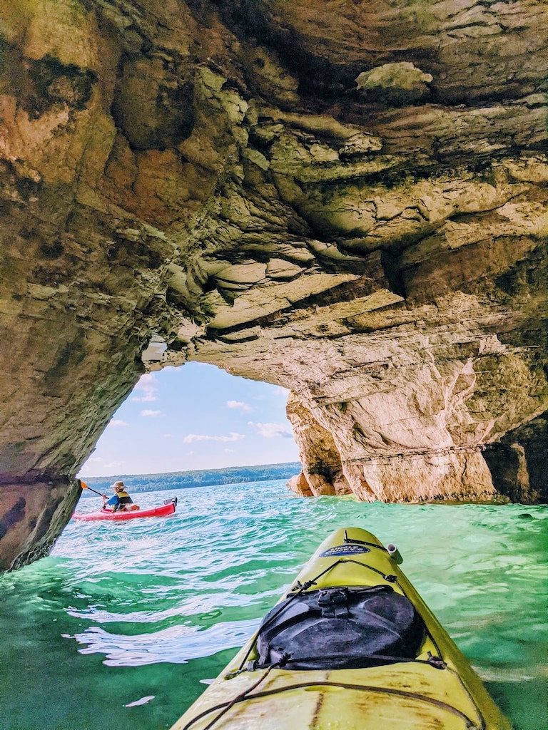 yellow and red kayaks under arch-best kayaking day trips in the US