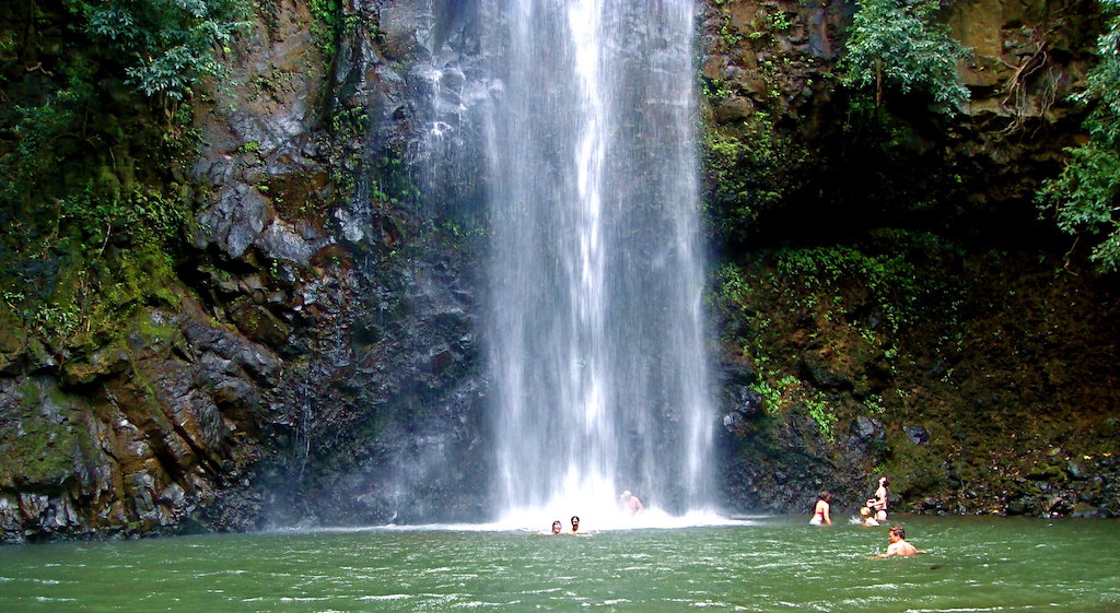 waterfall with people swimming