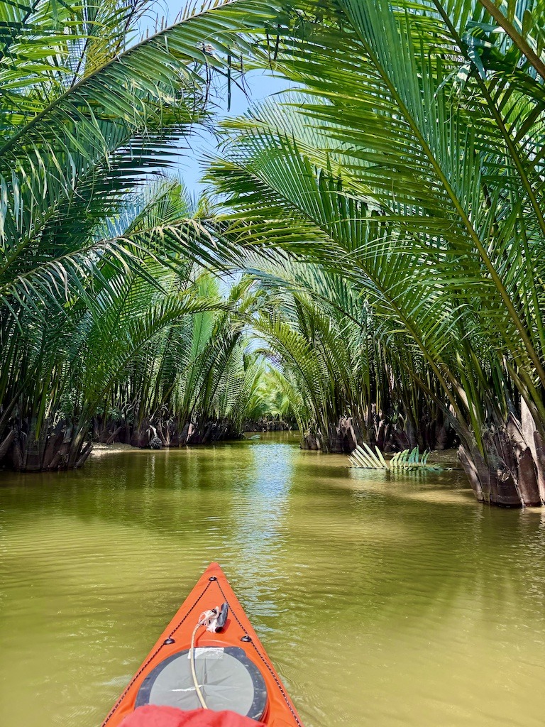 orange kayak on river under palm trees --Outdoor Adventures of Hoi An