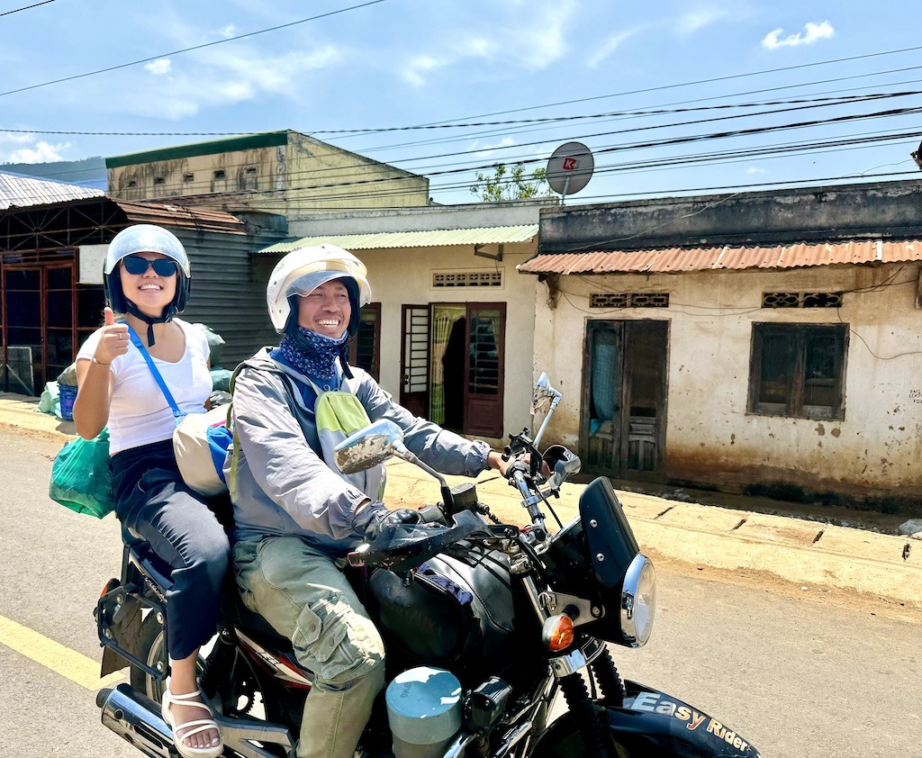 two people riding on a motorcycle and smiling