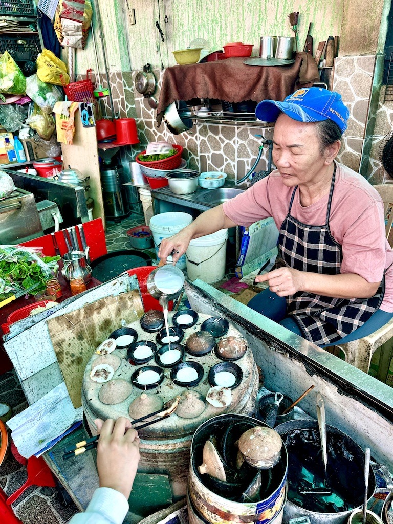 women pouring batter into round cups