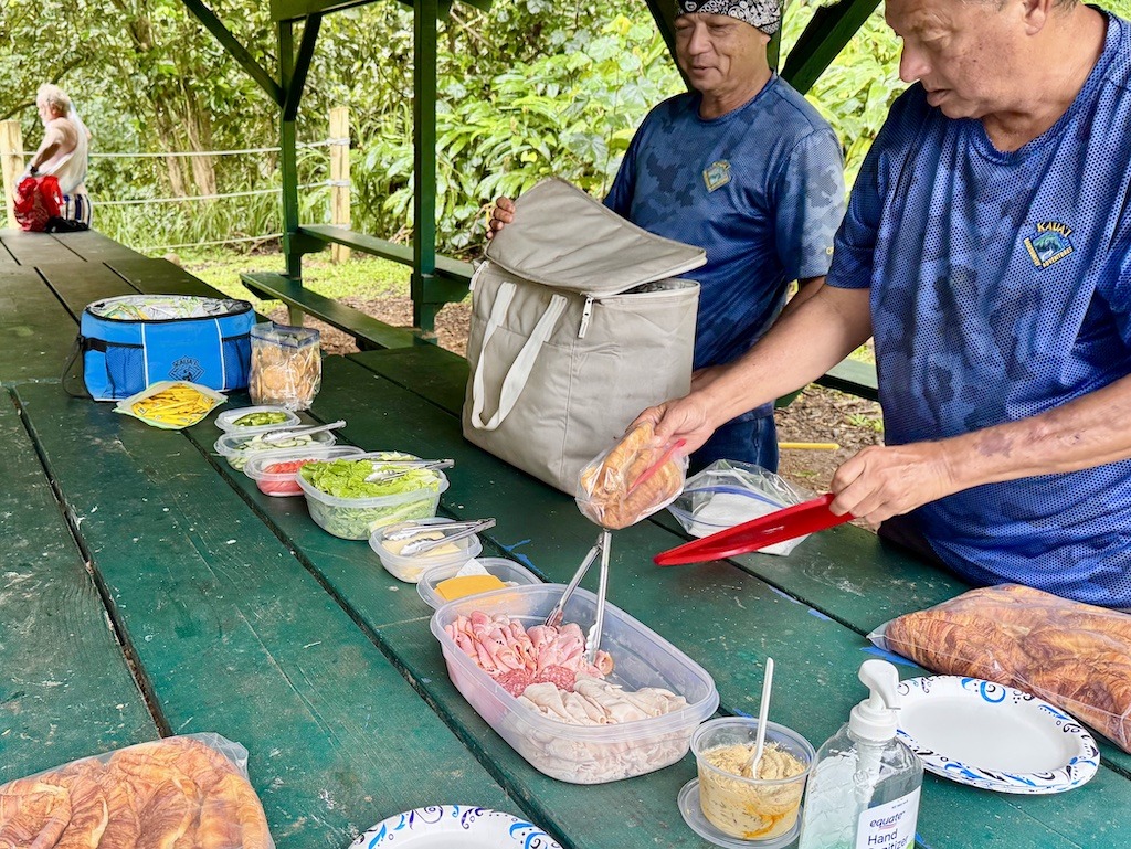 2 men in blue shirts preparing lunch while Sugarcane Plantation Tubing in Kauai