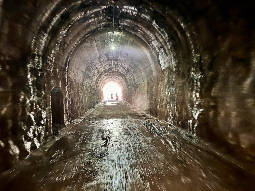 tunnel with two bikers while biking the Val del Zafán Greenway 