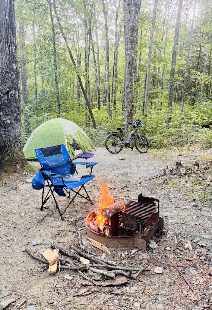 Green tent, blue chair, bike, and campfire-biking and camping in the Berkshires