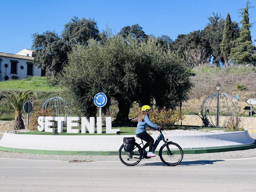 e-biking past white letters while doing outdoor adventures in Andalusia