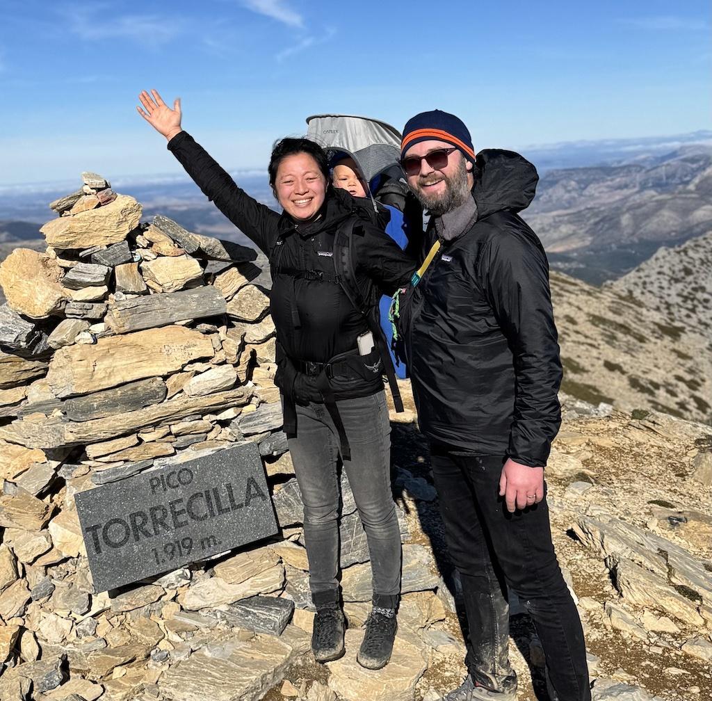 two people and baby on summet of peak while doing outdoor adventures in Andalusia