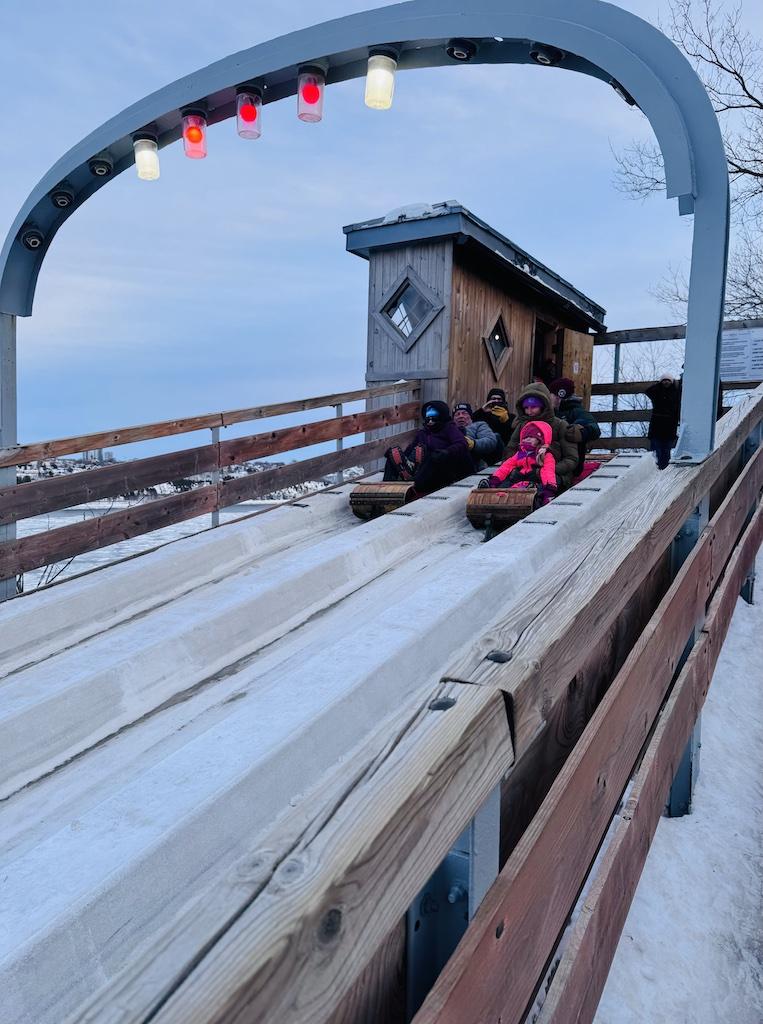 Two tobaggans with people start a run