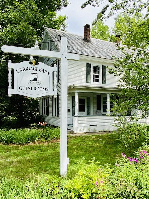 white house with sign-an inn to stay while biking in New Hampshire