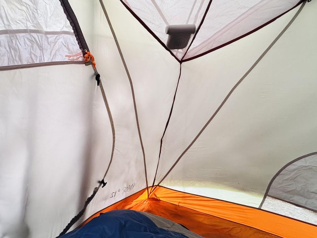 a trail fan in a tent pocket cooling off a grey and orange tent.