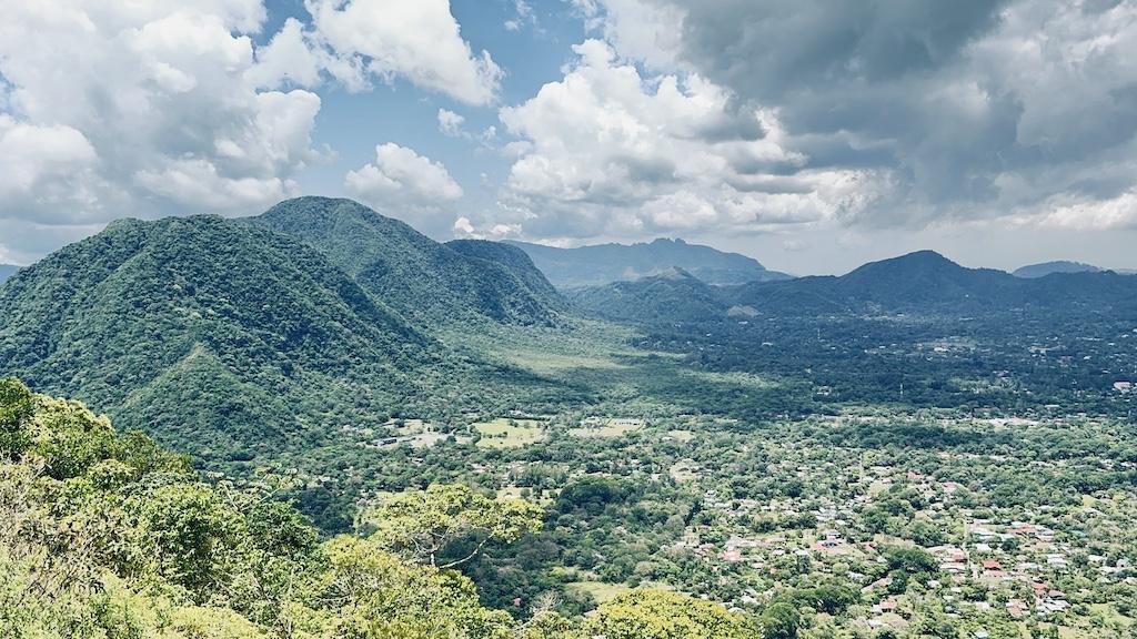 view of a town in a valley surrounded by green mountains on the India Dormida Hike