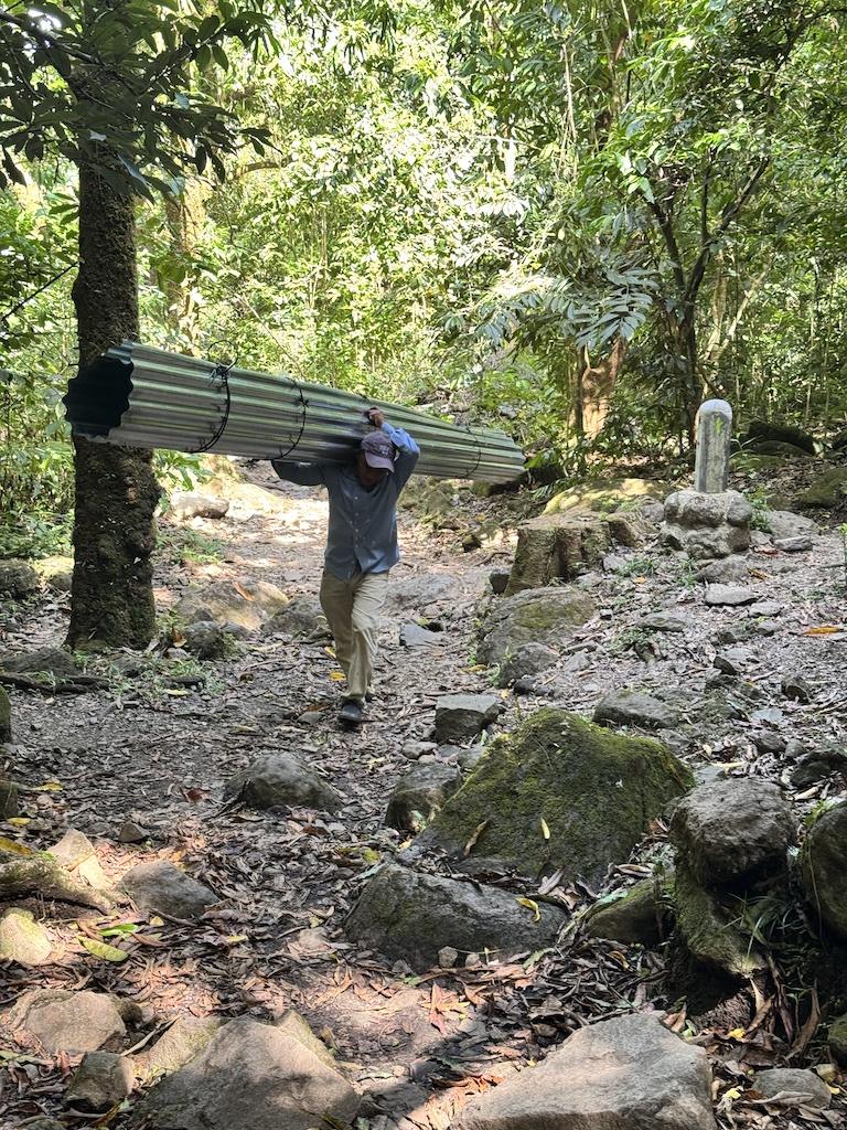 man in blue shirt carrying heave load on the India Dormida Hike