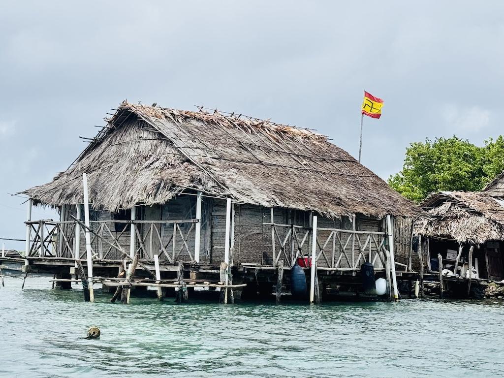thatched house and flag flying