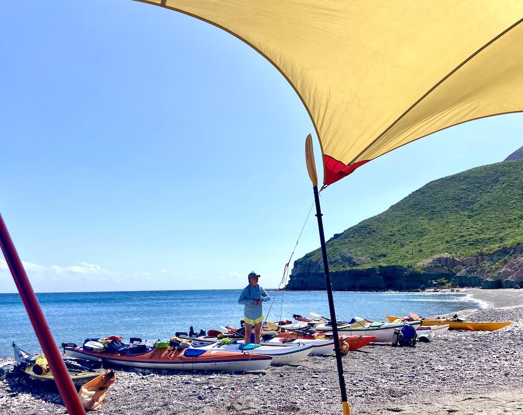 lots of kayaks and person on an International sea kayaking trip