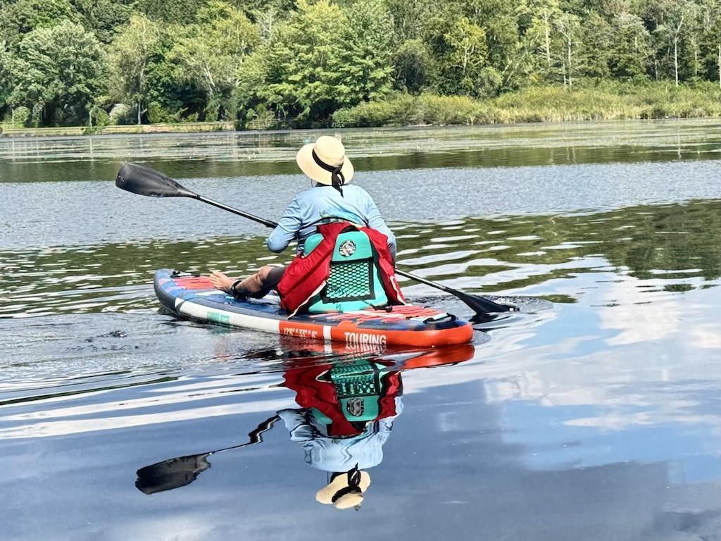 women with hat sitting on a paddle board-outdoor adventures in Bethel