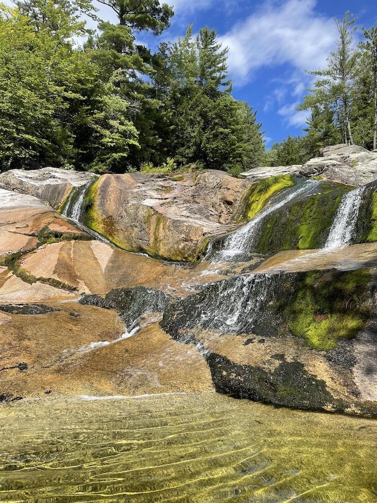 three waterfalls on green and brown rock-outdoor adventures in Bethel